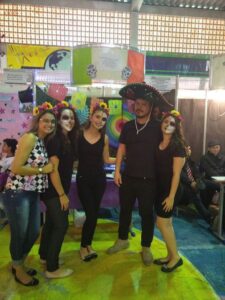 Equipe fantasiada com trajes escuros e caveiras e elementos que remetem à cultura mexicana e ao Dia de los Muertos.